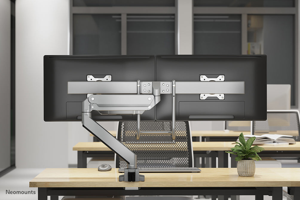 Neomounts NM-D775DX silver är ett gasfjädrat skrivbordsstöd med tvärstång och handtag för platta skärmar upp till 32 tum (81 cm).