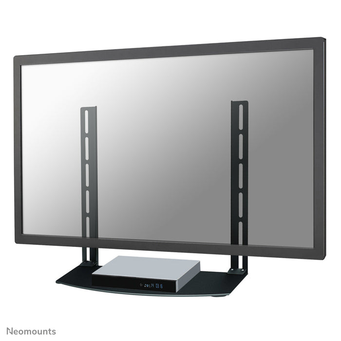 Neomounts AV-fäste, modell NS-SHELF100 är idealiskt för att placera AV-utrustning under väggfästen för platt-TV.